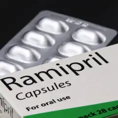 Opakowanie leku Ramipril Capsules, zawierające 28 kapsułek. Obok leży blister z lekami.