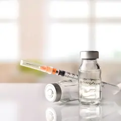 Dwie fiolki i strzykawka z lekiem, być może Diprophos, gotowe do podania.