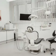 Nowoczesny gabinet stomatologiczny z fotelem dentystycznym i sprzętem.