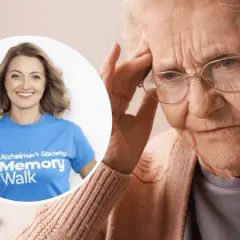 Starsza kobieta z bólem głowy, obok uśmiechnięta wolontariuszka Alzheimer's Society. Dowiedz się, czym jest demencja.