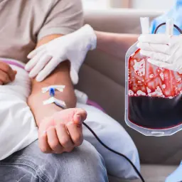 Krew płynie do worka, pielęgniarka w rękawiczkach nadzoruje proces. To praca hematologa, który dba o zdrowie pacjentów.