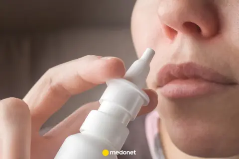 Dłoń trzymająca atomizer leku Avamys, gotowa do aplikacji do nosa.