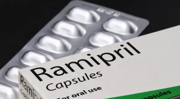 Opakowanie leku Ramipril Capsules, zawierające 28 kapsułek. Obok leży blister z lekami.