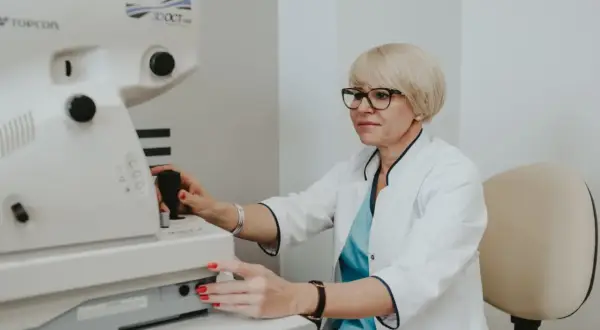 Okulistka wykonuje badanie dna oka za pomocą nowoczesnego urządzenia Topcon 3D OCT.