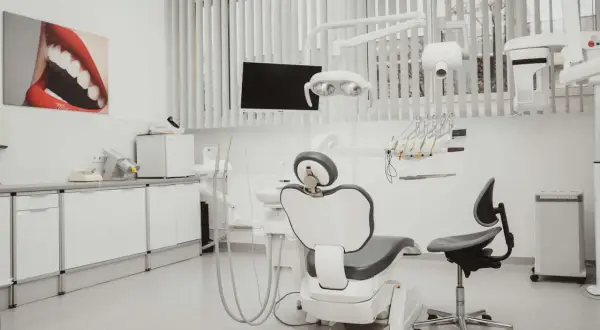 Nowoczesny gabinet stomatologiczny z fotelem dentystycznym i sprzętem.