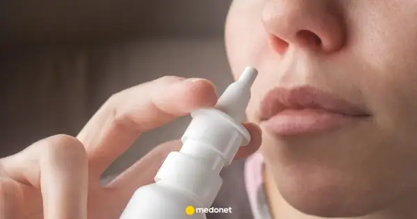 Dłoń trzymająca atomizer leku Avamys, gotowa do aplikacji do nosa.