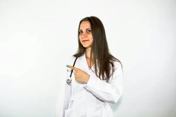 Lekarka w białym kitlu wskazuje palcem, sugerując, że tu jest rozwiązanie, jak Beloderm na problemy skórne.